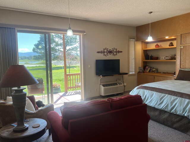 bedroom with a textured ceiling and access to exterior