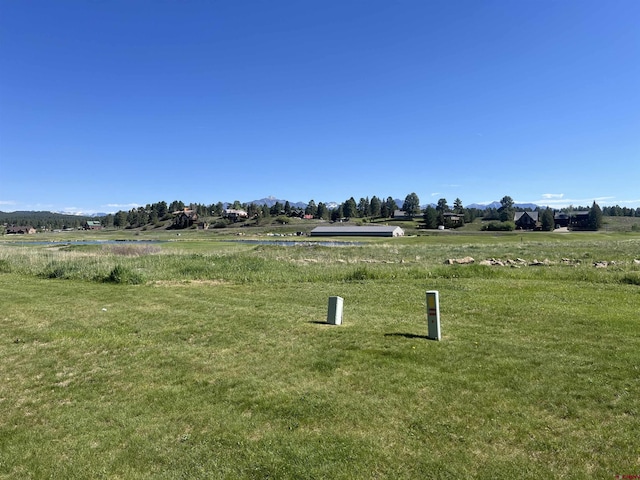 view of community with a rural view and a lawn