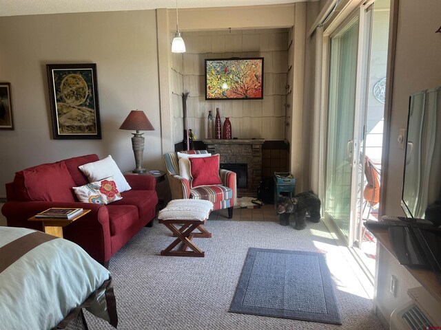 living room with a stone fireplace and carpet floors