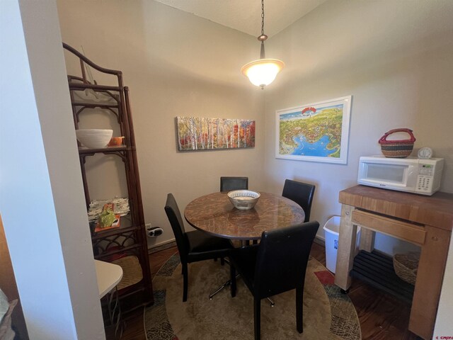 dining area featuring vaulted ceiling and hardwood / wood-style floors