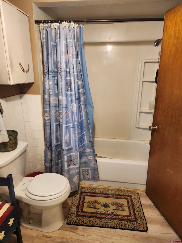 bathroom featuring tile walls, shower / tub combo with curtain, toilet, and wood-type flooring