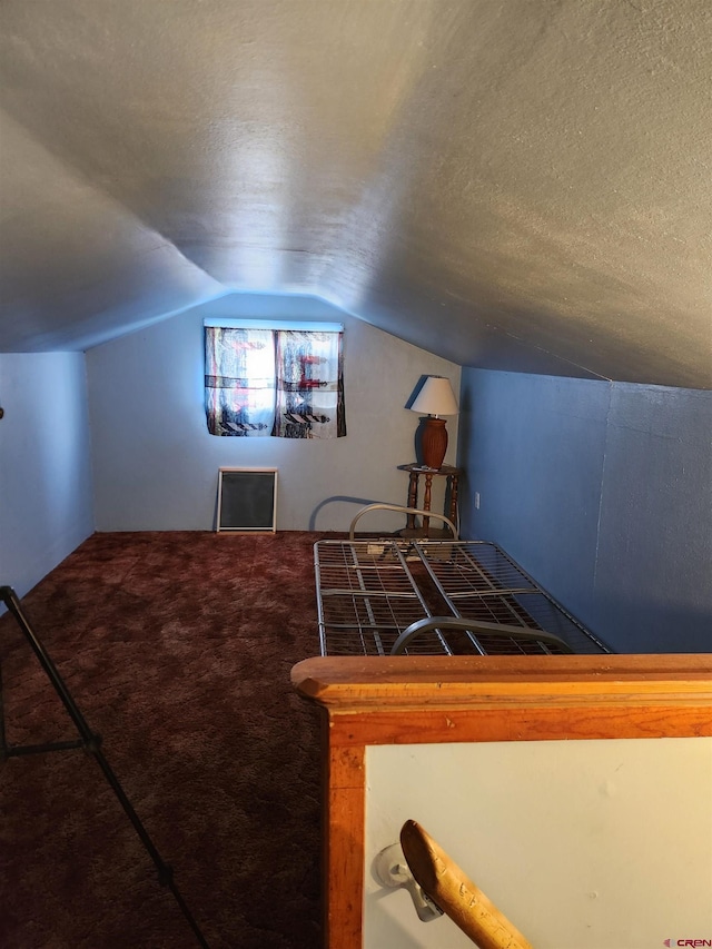 rec room featuring a textured ceiling, carpet floors, and lofted ceiling