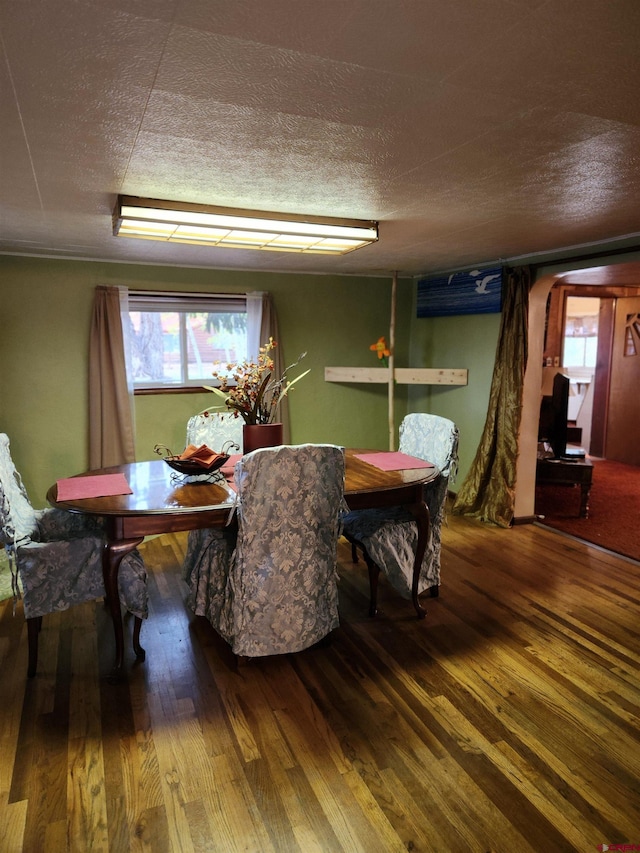 dining room with a textured ceiling and hardwood / wood-style floors