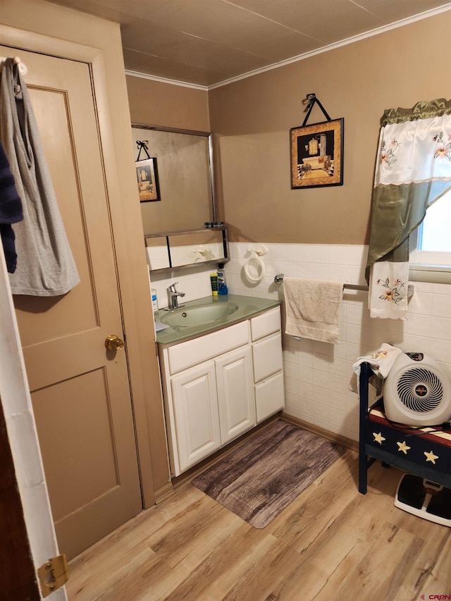 bathroom featuring tile walls, crown molding, vanity, and hardwood / wood-style floors