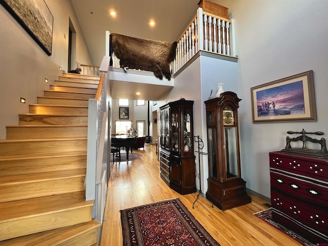 stairs featuring a high ceiling and hardwood / wood-style flooring