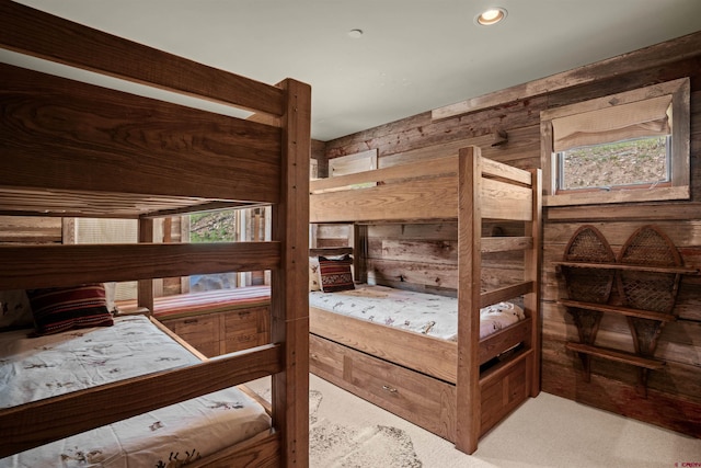 carpeted bedroom featuring wooden walls