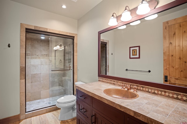 bathroom with walk in shower, hardwood / wood-style flooring, vanity, and toilet