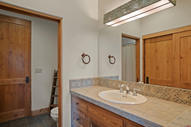 bathroom with tile patterned flooring, vanity, toilet, and backsplash