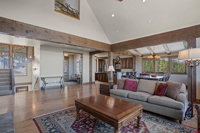 living room featuring a chandelier, wood-type flooring, and high vaulted ceiling