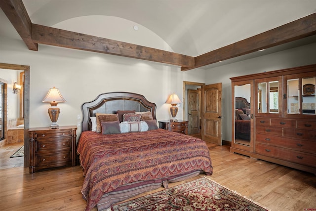 bedroom featuring connected bathroom and light hardwood / wood-style floors