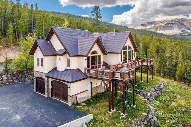 view of front of house with a deck with mountain view and a garage