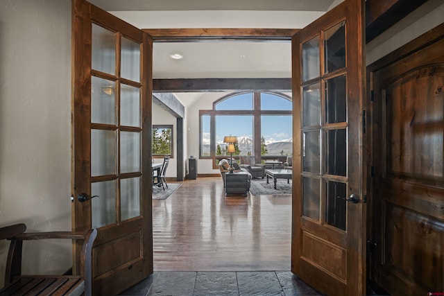 corridor featuring a mountain view, dark wood-type flooring, and french doors