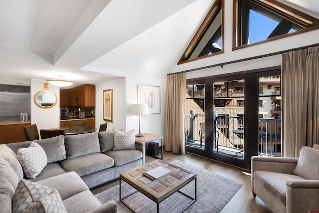 living room with high vaulted ceiling and light wood-type flooring