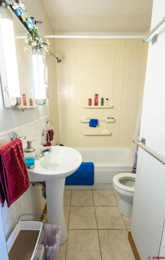 bathroom with tile flooring, washtub / shower combination, and toilet