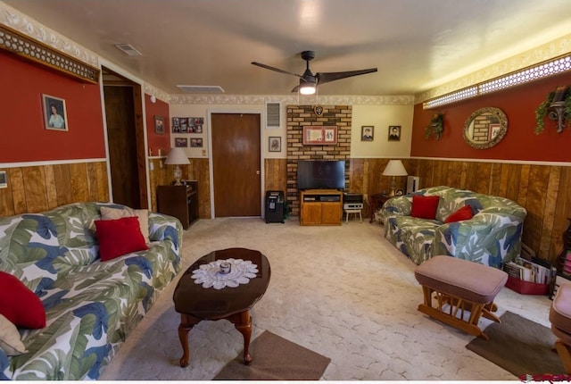 carpeted living room with brick wall and ceiling fan