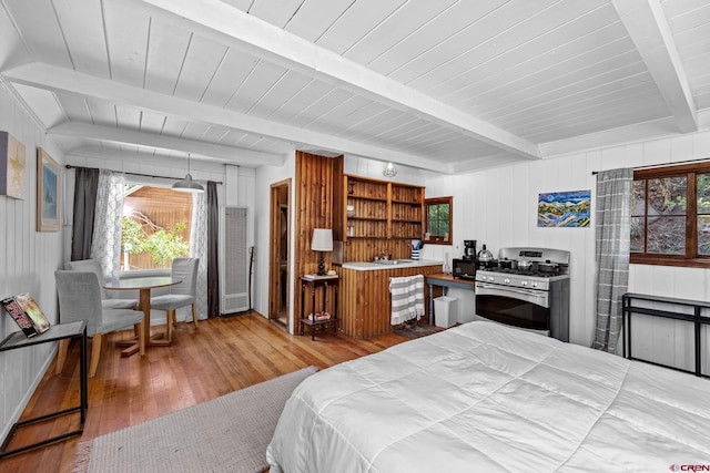 bedroom featuring beamed ceiling and hardwood / wood-style flooring