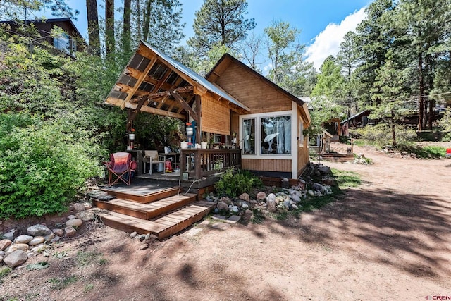 rear view of house featuring a wooden deck