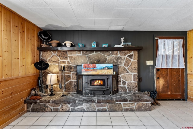 details with tile floors, wooden walls, and a wood stove