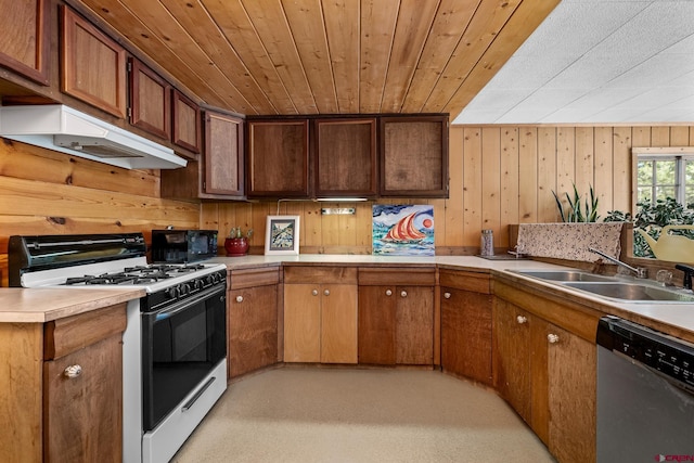 kitchen featuring gas range gas stove, dishwasher, wood ceiling, wooden walls, and sink