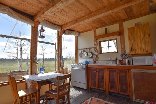 kitchen featuring beam ceiling, white appliances, sink, and wood ceiling