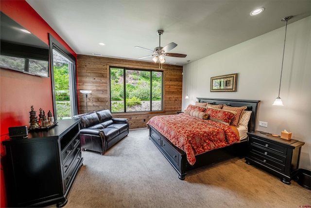 bedroom featuring carpet, ceiling fan, and wood walls