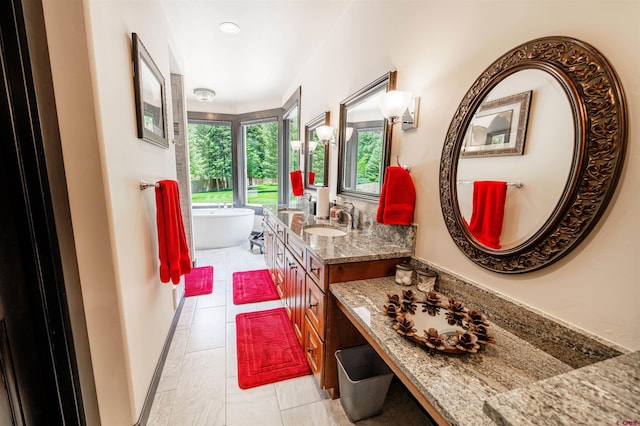 bathroom with vanity with extensive cabinet space, a bath, and tile floors