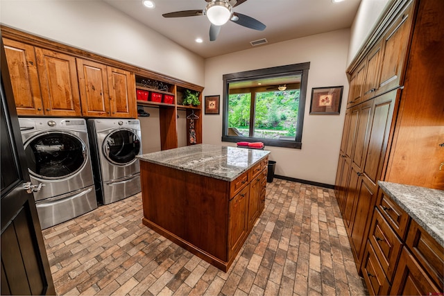 laundry room with ceiling fan, washing machine and clothes dryer, and cabinets