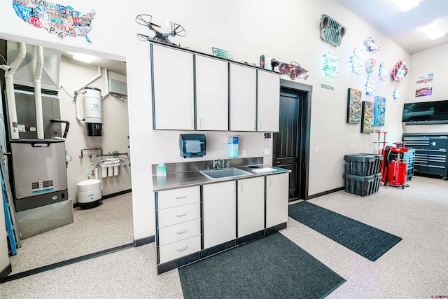 kitchen featuring sink, stainless steel counters, and white cabinetry