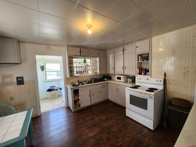 kitchen with dark wood-type flooring, white cabinetry, tile walls, and white appliances