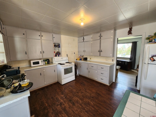 kitchen featuring dark wood-type flooring, light countertops, white appliances, and white cabinets