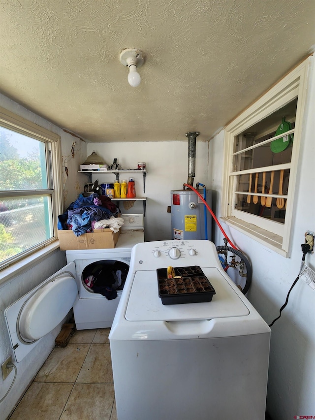 clothes washing area featuring a textured ceiling, gas water heater, and light tile floors