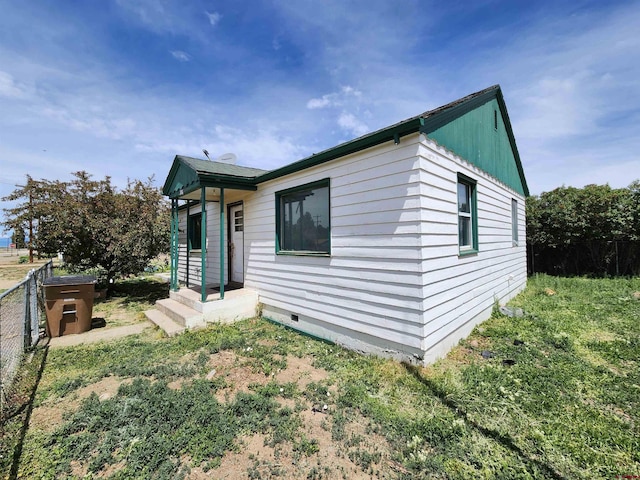 view of front of property with crawl space and fence
