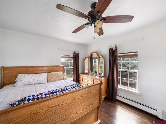 bedroom with a baseboard heating unit, ceiling fan, and dark hardwood / wood-style flooring