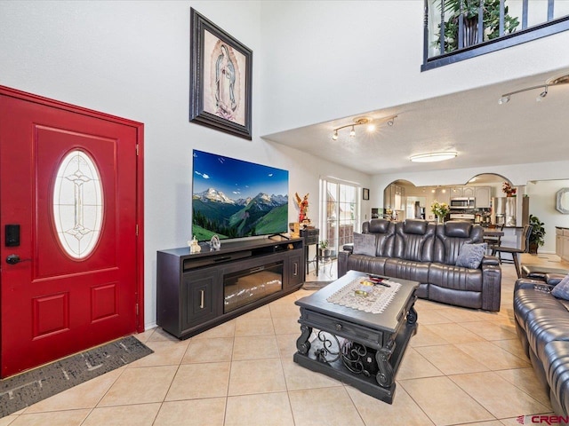 tiled living room with a textured ceiling and rail lighting