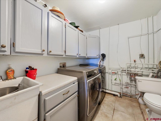 clothes washing area with light tile flooring, washer and clothes dryer, and hookup for a washing machine