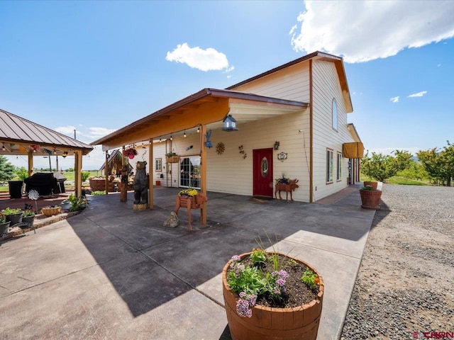 view of side of property featuring a patio and a gazebo