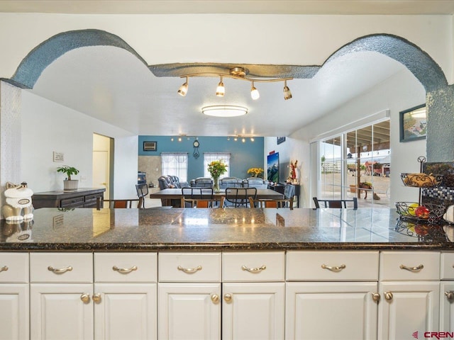 kitchen with track lighting, white cabinetry, and plenty of natural light