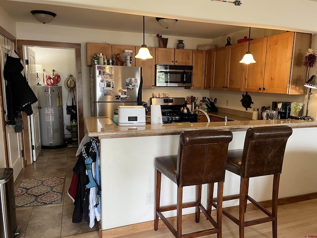 kitchen featuring a breakfast bar, electric water heater, decorative light fixtures, kitchen peninsula, and stainless steel appliances