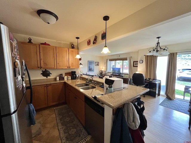 kitchen with sink, stainless steel appliances, kitchen peninsula, light hardwood / wood-style floors, and decorative light fixtures