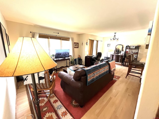 living room featuring light hardwood / wood-style floors and a notable chandelier