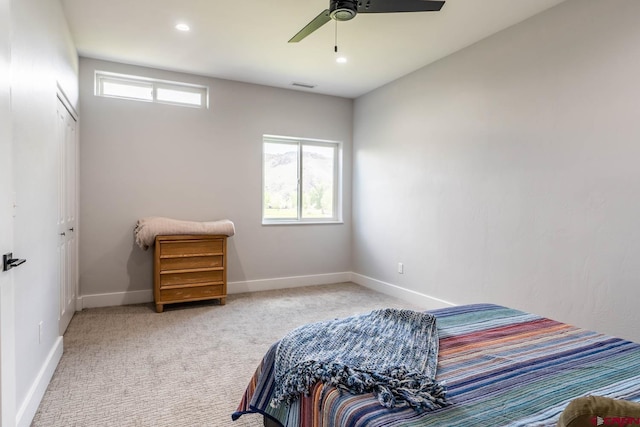 carpeted bedroom featuring ceiling fan and a closet