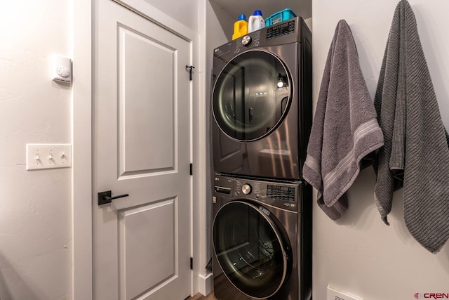 clothes washing area with stacked washer and clothes dryer