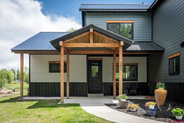 property entrance featuring covered porch and a yard