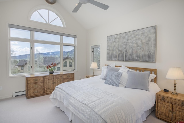 bedroom with multiple windows, a mountain view, ceiling fan, and a baseboard radiator