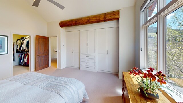 bedroom with high vaulted ceiling, ceiling fan, beam ceiling, light colored carpet, and a closet