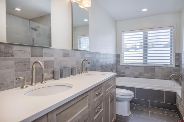 full bathroom with vanity, tile patterned flooring, toilet, shower with separate bathtub, and tile walls