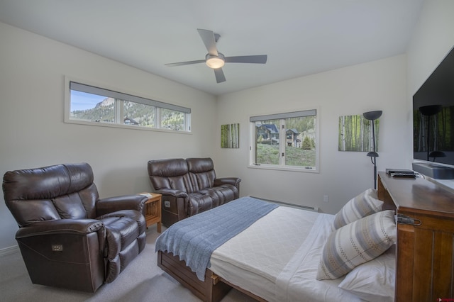 carpeted bedroom with multiple windows, a baseboard heating unit, and ceiling fan