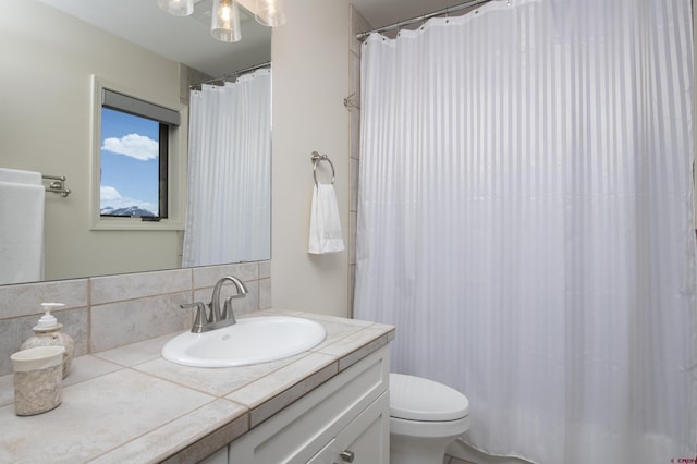 bathroom featuring vanity, tasteful backsplash, and toilet