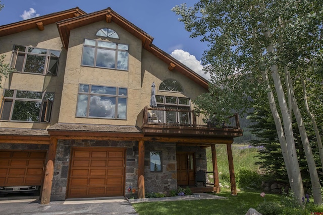 back of property with a balcony and a garage