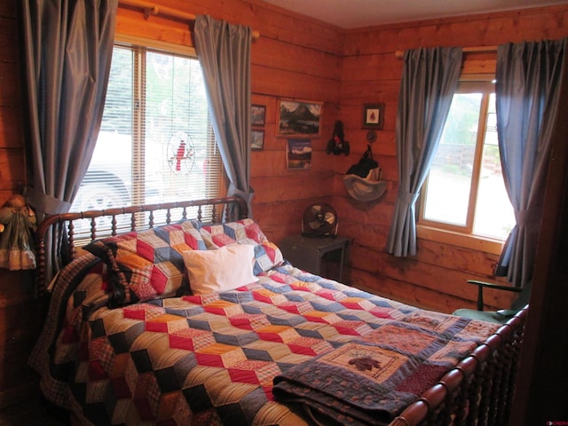 bedroom featuring wooden walls